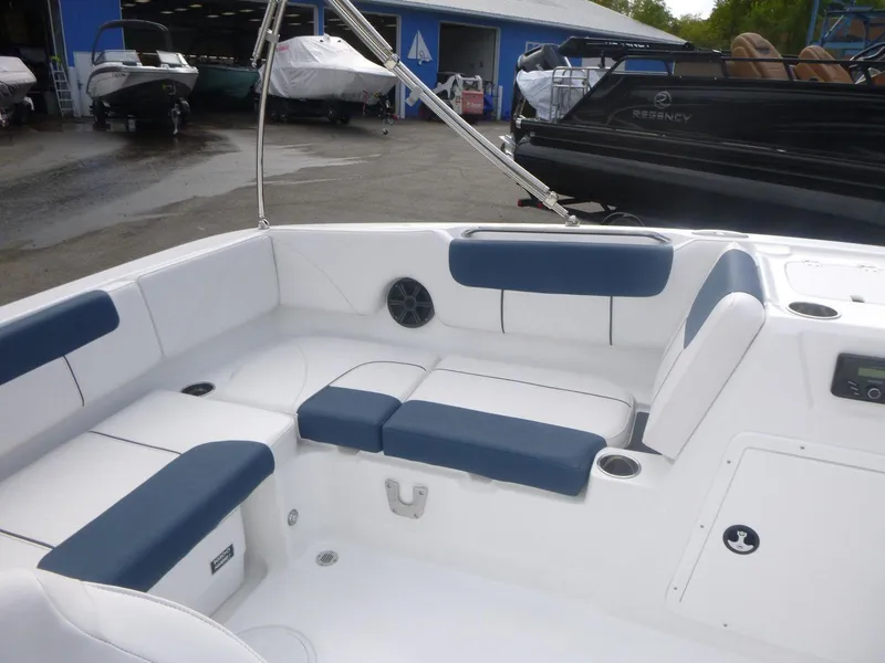 Slide: The Image of 2024 Tahoe 1950 boat interior with blue and white seating, docked near other boats. - 15