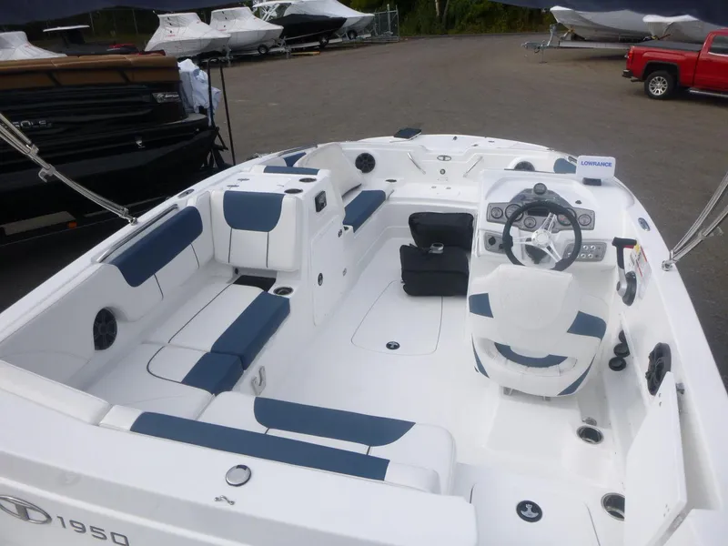Slide: The Image of 2024 Tahoe 1950 boat interior with blue and white seating, steering wheel, and spacious layout. - 19