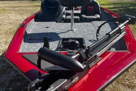 Slide: The Image of 2025 Tracker Pro Team 175 boat with Minn Kota trolling motor, red exterior, and spacious deck. - 2