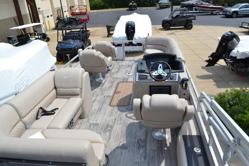 Slide: The Image of 2024 Ranger Reata 223FC pontoon boat with beige seating and modern dashboard. - 2