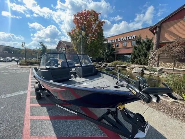 Slide: The Image of 2025 Tracker Pro Guide V-16 WT boat displayed outside a boat center. - 2