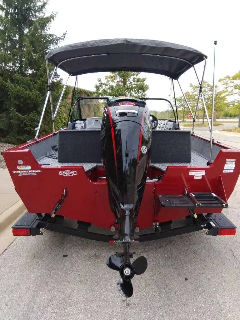 Slide: The Image of 2025 Tracker Pro Guide V-175 Combo boat, rear view, red exterior, parked outdoors. - 4