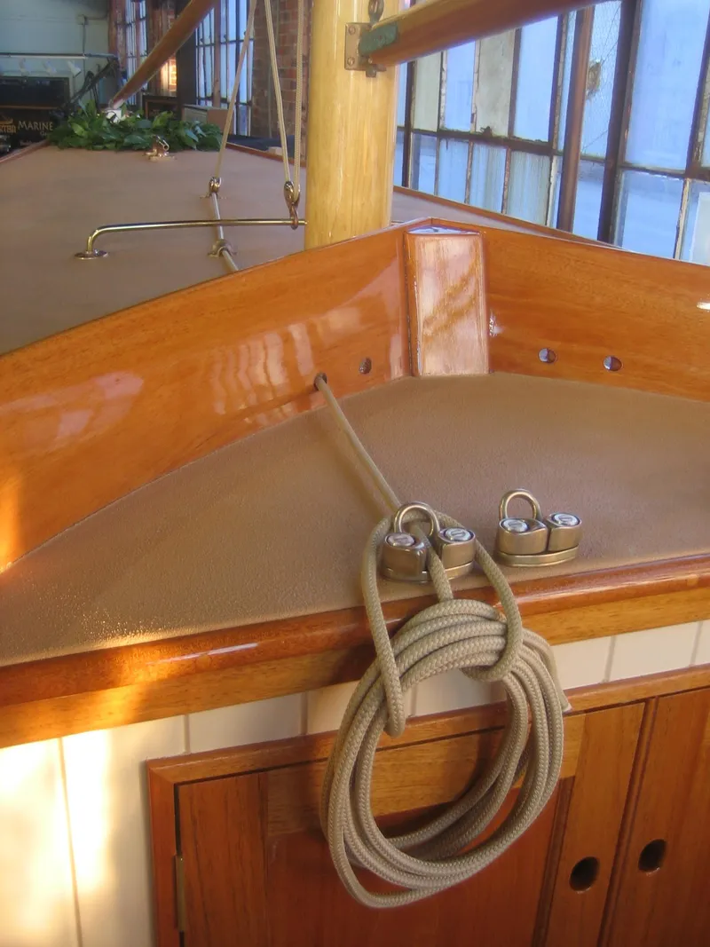 Slide: The Image of 2008 Herreshoff Full-Keel Buzzards Bay 15 sailboat interior with wooden finish and rope details. - 11