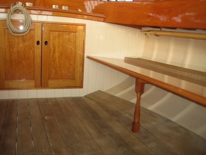 Slide: The Image of Interior of 2008 Herreshoff Full-Keel Buzzards Bay 15 with wooden cabinetry and seating. - 13