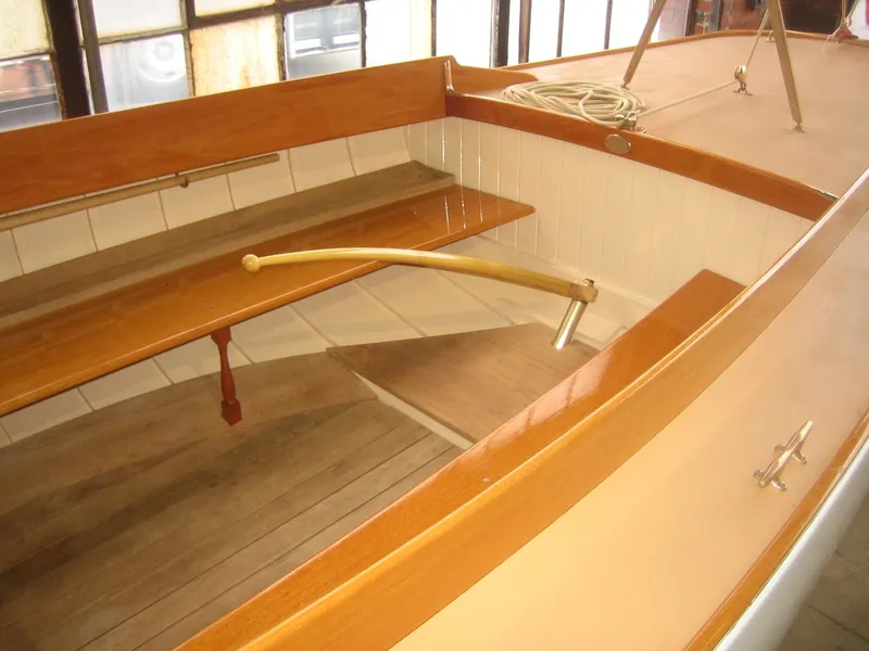 Slide: The Image of 2008 Herreshoff Full-Keel Buzzards Bay 15 interior with wooden seating and tiller. - 16