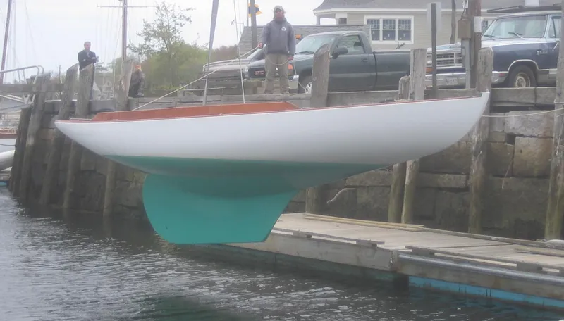 Slide: The Image of 2008 Herreshoff Full-Keel Buzzards Bay 15 sailboat being launched at a dock. - 8