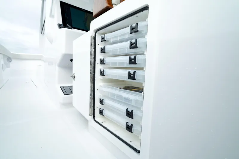 Slide: The Image of Storage compartment on 2025 Front Runner 37 Catamaran, featuring organized tackle boxes. - 12