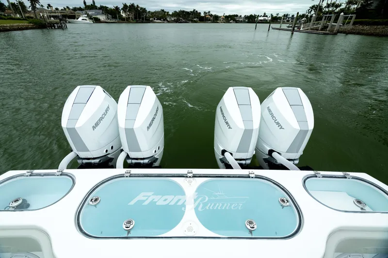 Slide: The Image of 2025 Front Runner 37 Catamaran with four Mercury outboard engines on a calm waterway. - 43