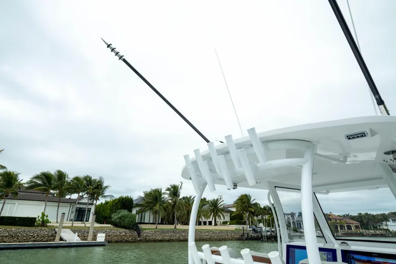 Slide: The Image of 2025 Front Runner 37 Catamaran docked, featuring fishing rod holders and tropical backdrop. - 44