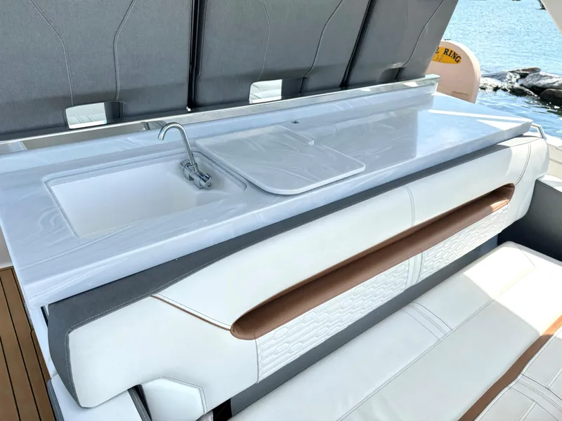 Slide: The Image of 2020 Tiara Sport 34 LS boat interior with sleek white seating and compact sink. - 13
