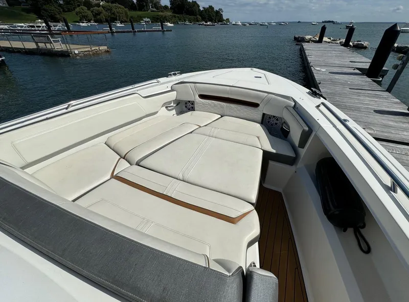 Slide: The Image of 2020 Tiara Sport 34 LS boat with spacious seating, docked by a scenic waterfront. - 19