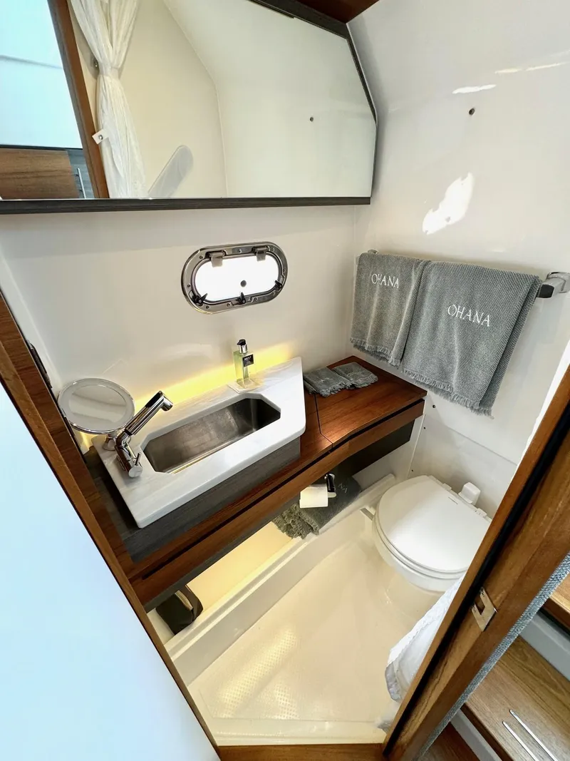 Slide: The Image of 2020 Tiara Sport 34 LS boat bathroom with sink, mirror, and toilet. - 24