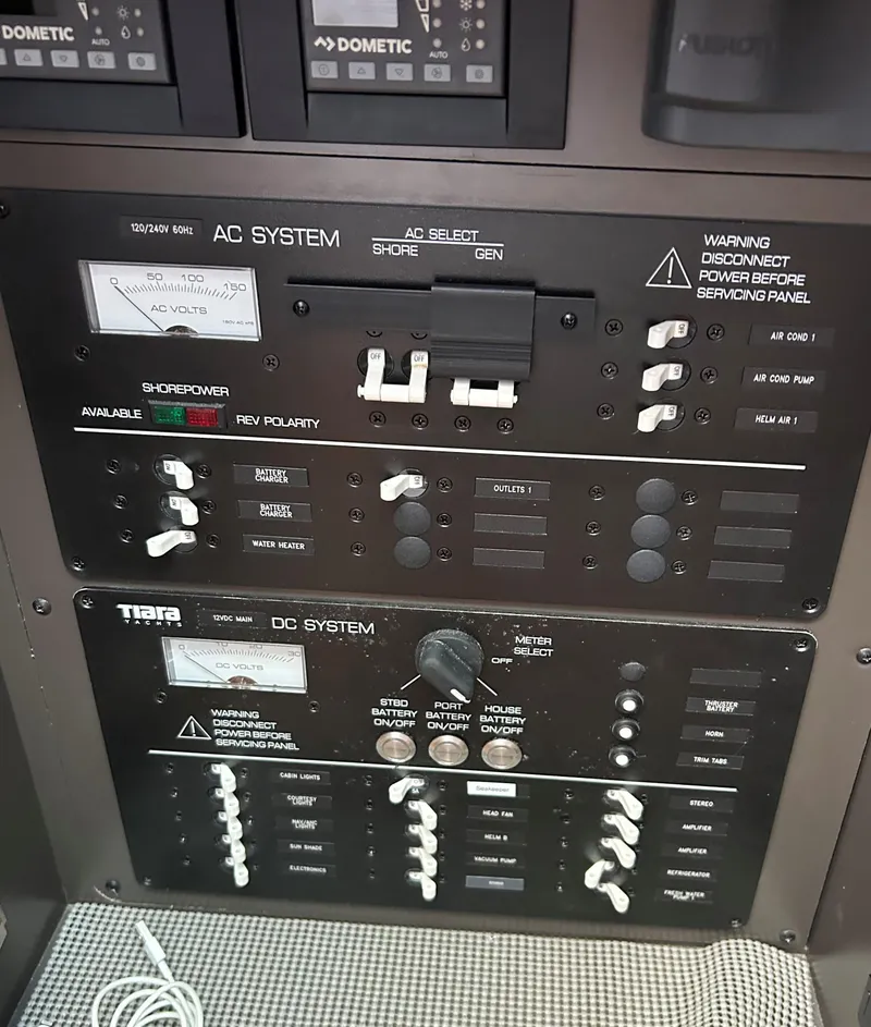 Slide: The Image of Control panel of a 2020 Tiara Sport 34 LS boat, featuring AC and DC systems. - 25