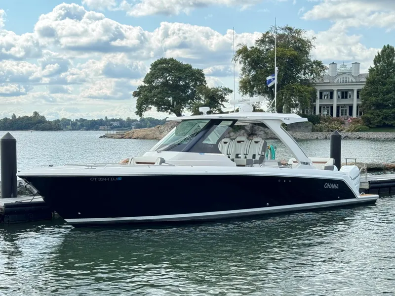 Slide: The Image of 2020 Tiara Sport 34 LS boat docked by a scenic waterfront estate. - 6