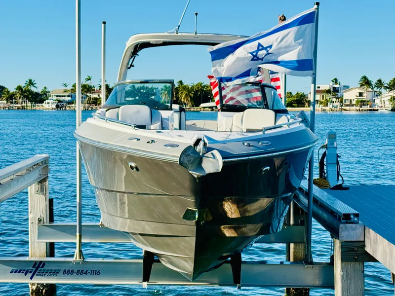Slide: The Image of 2020 Monterey 328 SS boat docked with flags, scenic waterfront view. - 0