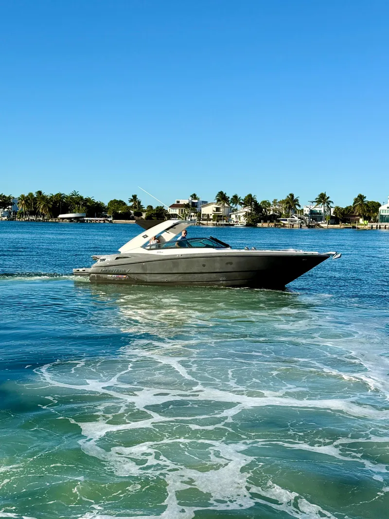 Slide: The Image of 2020 Monterey 328 SS boat cruising on a sunny day in a coastal area. - 17