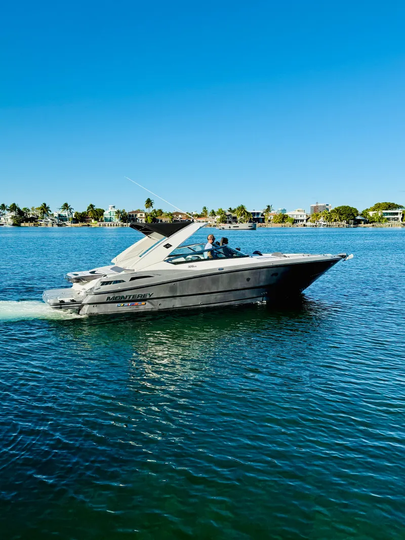 Slide: The Image of 2020 Monterey 328 SS boat cruising on a sunny day in calm waters. - 18