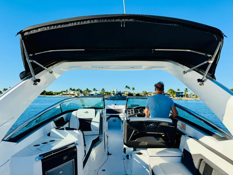 Slide: The Image of 2020 Monterey 328 SS boat cruising on a sunny day, with a scenic waterfront view. - 31