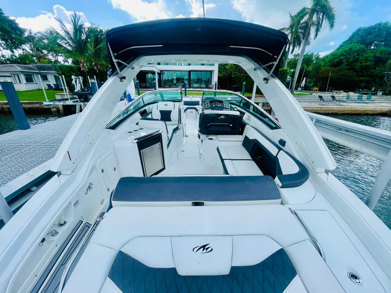 Slide: The Image of 2020 Monterey 328 SS boat with spacious seating and sleek design at a dock. - 33