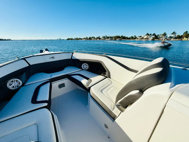 Slide: The Image of 2020 Monterey 328 SS boat interior on a sunny day, with water and jet ski in background. - 39