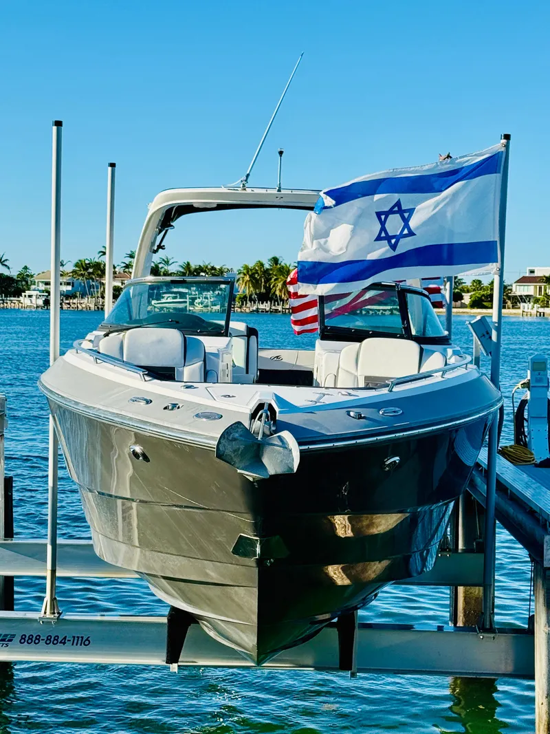 Slide: The Image of 2020 Monterey 328 SS boat docked, displaying Israeli and American flags. - 4