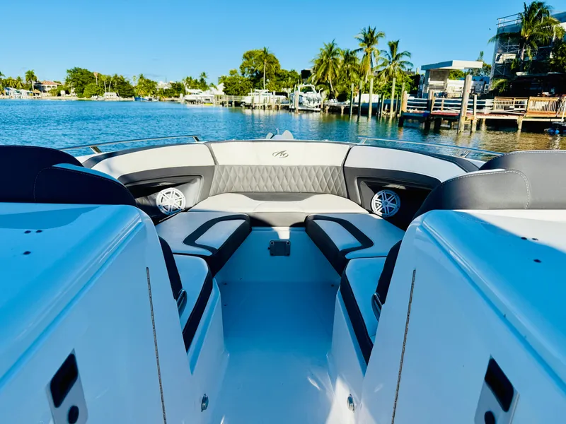 Slide: The Image of 2020 Monterey 328 SS boat interior with luxurious seating, docked by a scenic waterfront. - 40