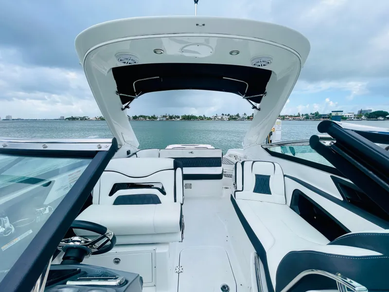 Slide: The Image of 2020 Monterey 328 SS boat interior with sleek white seating and open water view. - 42