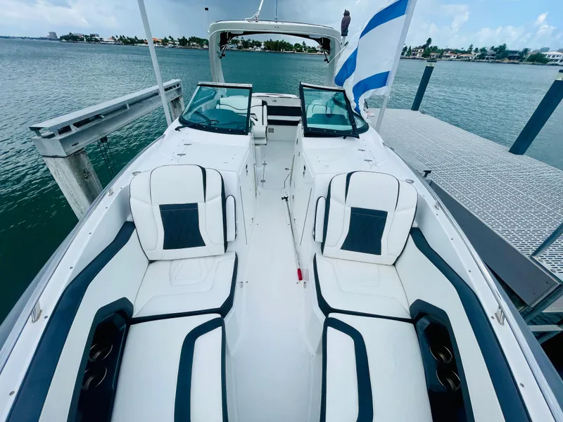 Slide: The Image of 2020 Monterey 328 SS boat with white and navy seating, docked by the water. - 45