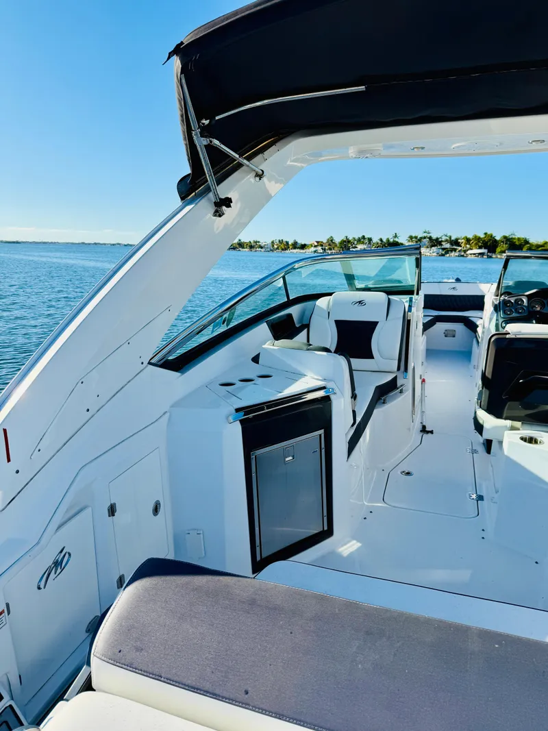Slide: The Image of 2020 Monterey 328 SS boat interior with sleek seating and open water view. - 49