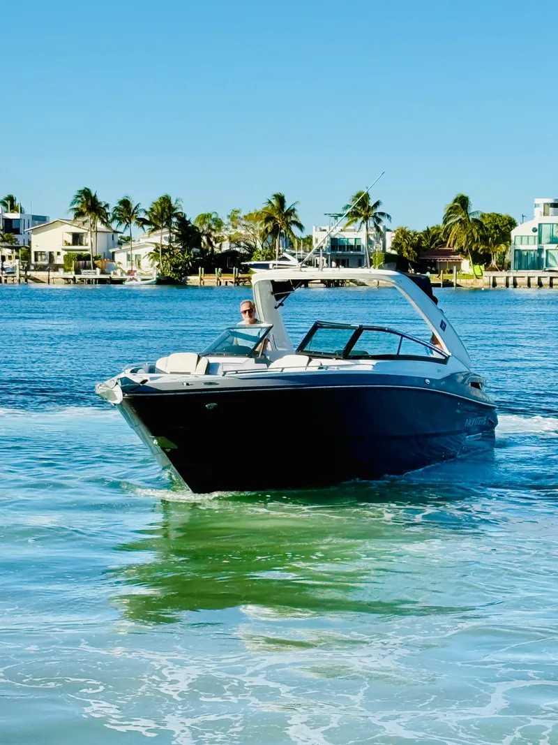 Slide: The Image of 2020 Monterey 328 SS boat cruising on a sunny day near coastal homes. - 7