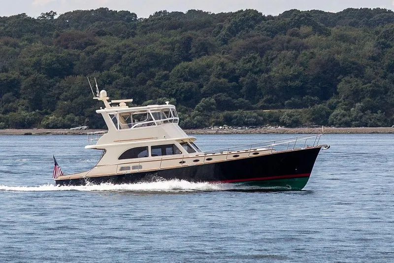 Slide: The Image of 2007 Vicem 54 Classic Flybridge yacht with American flag, cruising on open water. - 3