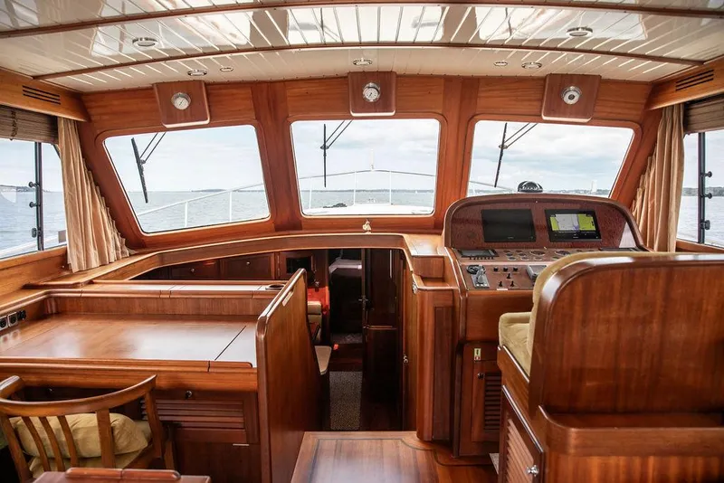 Slide: The Image of 2007 Vicem 54 Classic Flybridge interior with wooden table, overlooking serene waters. - 39