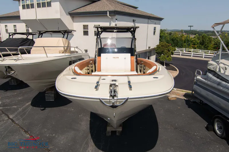 Slide: The Image of 2024 Capoforte FX270 boat displayed outdoors, front view, near a building. - 1
