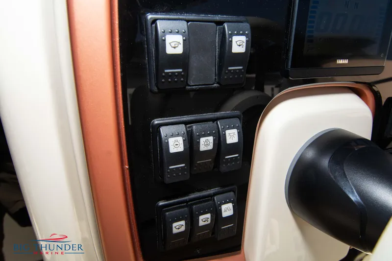 Slide: The Image of Control panel of 2024 Capoforte FX270 boat with multiple switches and steering wheel. - 27
