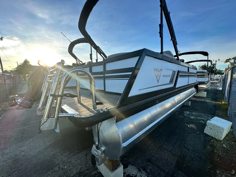 Slide: The Image of 2023 Viaggio Diamante 21U pontoon boat at sunset, showcasing sleek design and ladder. - 3