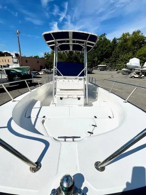 Slide: The Image of 2017 Boston Whaler 210 Montauk boat with canopy, docked outdoors under blue sky. - 17