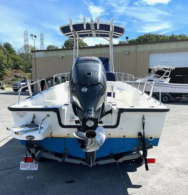 Slide: The Image of 2017 Boston Whaler 210 Montauk boat with outboard motor, parked outdoors. - 8
