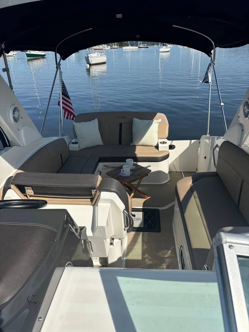 Slide: The Image of 2017 Sea Ray Sundancer 260 boat interior with seating, docked on a calm lake. - 10