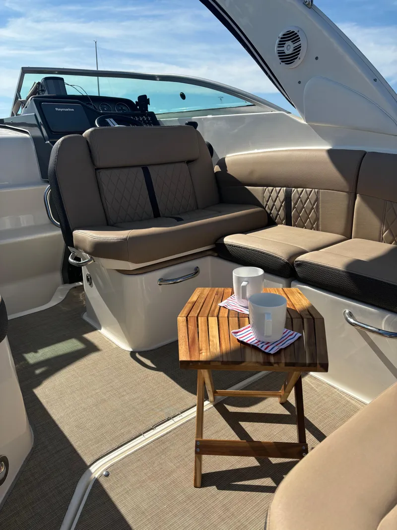 Slide: The Image of Interior of 2017 Sea Ray Sundancer 260 with cozy seating and a small table. - 11