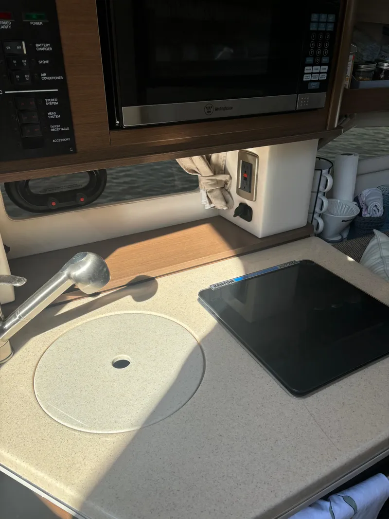 Slide: The Image of 2017 Sea Ray Sundancer 260 kitchen area with sink and microwave. - 16