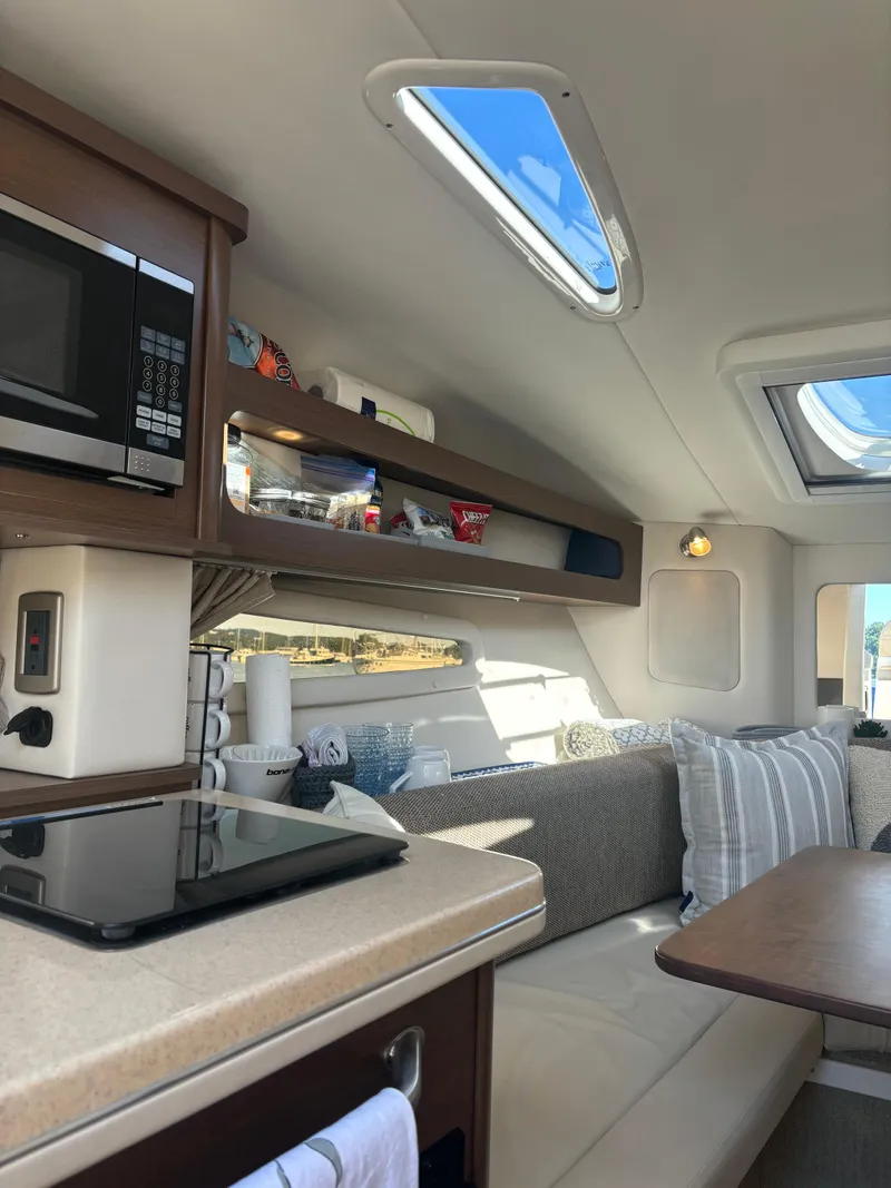 Slide: The Image of Interior of 2017 Sea Ray Sundancer 260, featuring cozy seating and modern amenities. - 17