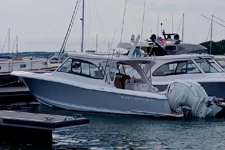 The Image of 2020 Southport 33 DC boat docked in marina, featuring sleek design and dual outboard engines. - 0