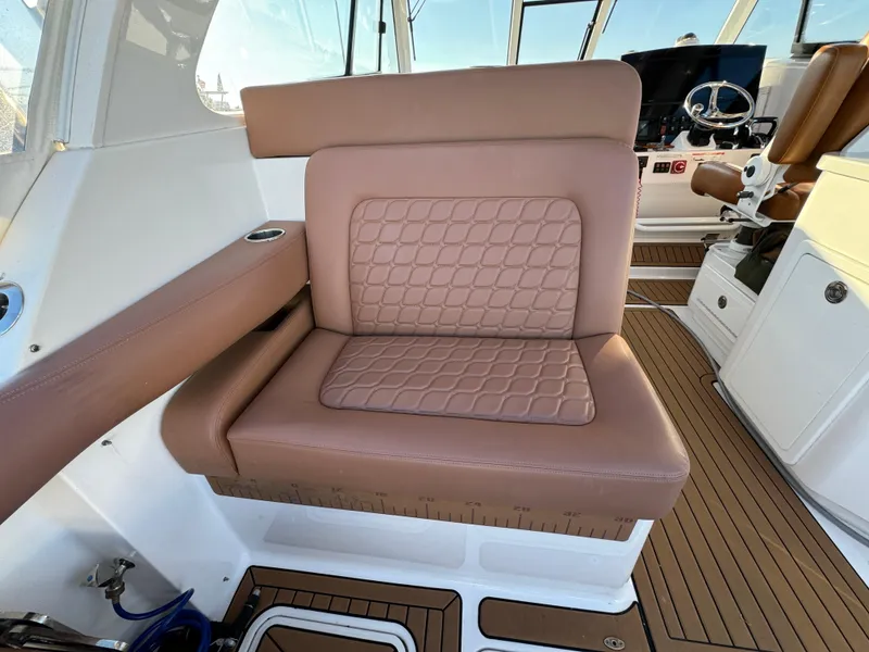 Slide: The Image of Luxurious seating on 2020 Southport 33 DC boat, featuring quilted brown upholstery. - 11