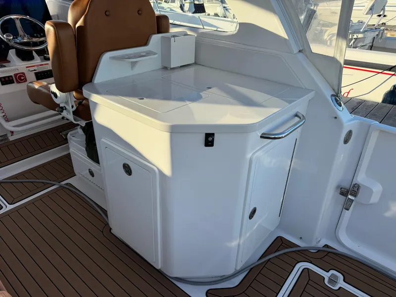 Slide: The Image of 2020 Southport 33 DC boat interior with white cabinetry and brown seating. - 14