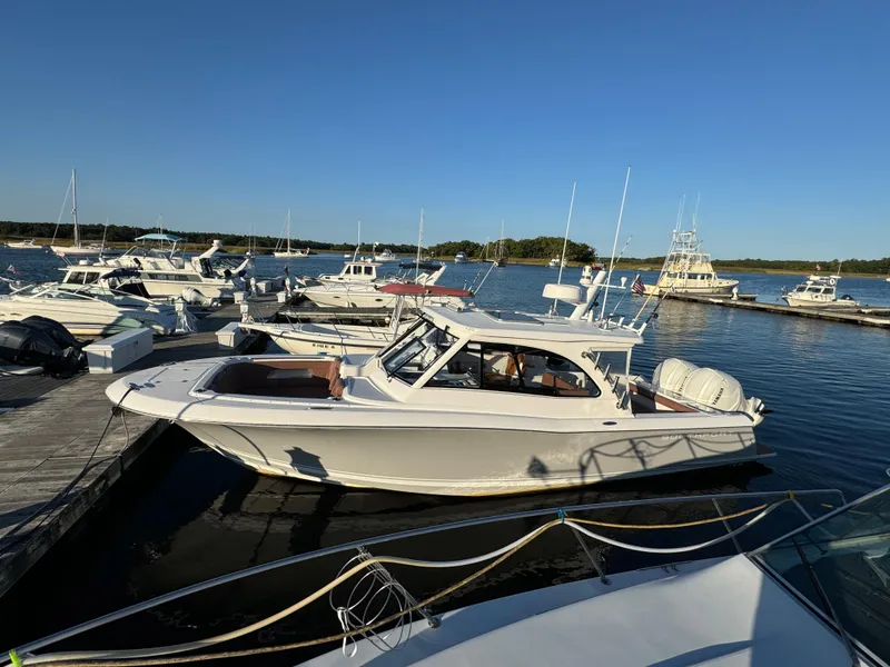 Slide: The Image of 2020 Southport 33 DC boat docked at a marina under clear blue skies. - 2