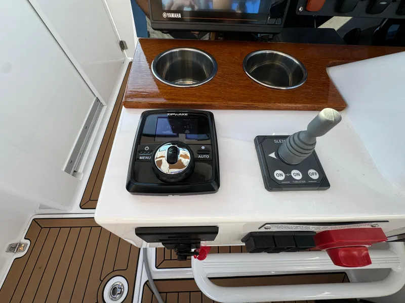 Slide: The Image of Control panel of a 2020 Southport 33 DC boat with joystick and cup holders. - 23
