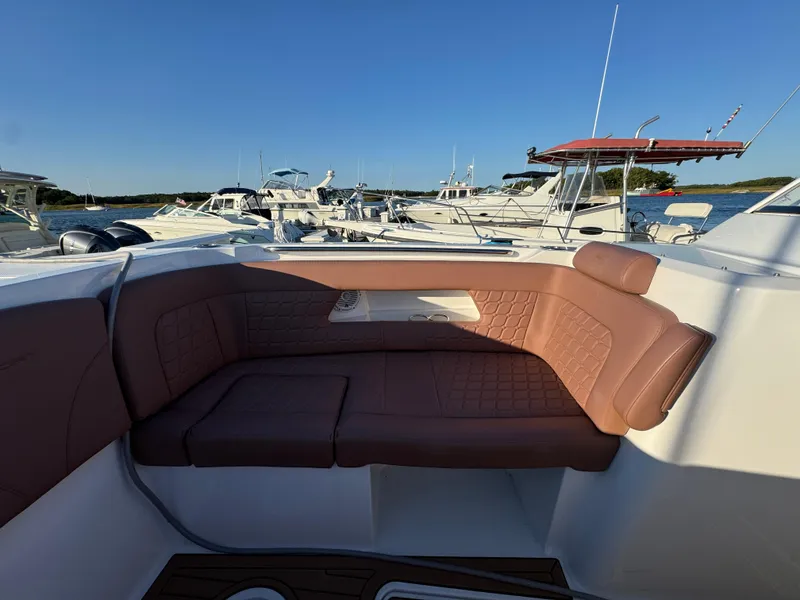 Slide: The Image of 2020 Southport 33 DC boat with brown seating, docked among other boats. - 33