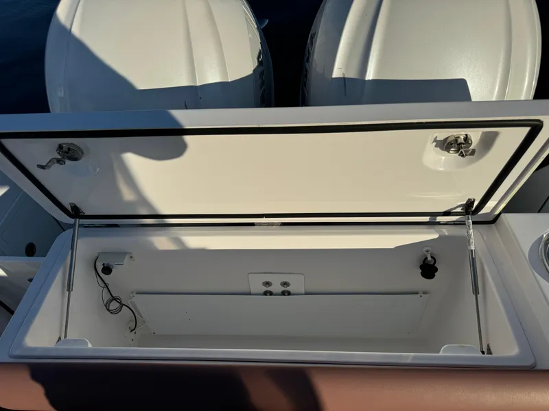 Slide: The Image of Open storage compartment on a 2020 Southport 33 DC boat, with visible engine covers. - 8
