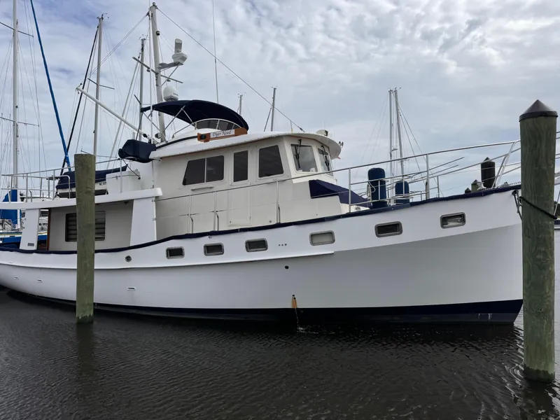 Slide: The Image of 1996 Kadey-Krogen 48 yacht docked at marina, featuring classic design and white hull. - 10