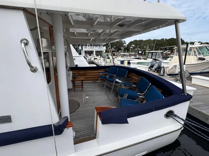 Slide: The Image of Kadey-Krogen 48 yacht, 1996 model, featuring a spacious deck with blue seating at a marina. - 13